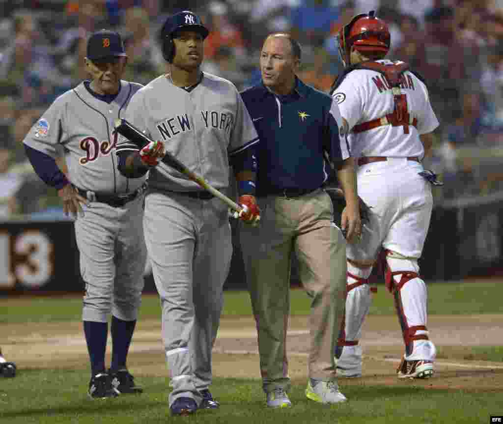 Robinson Cano (i) de los Yanquis sale del campo tras ser golpeado por una bola lanzada por Matt Harvey de los Mets durante el Juego de las Estrellas.